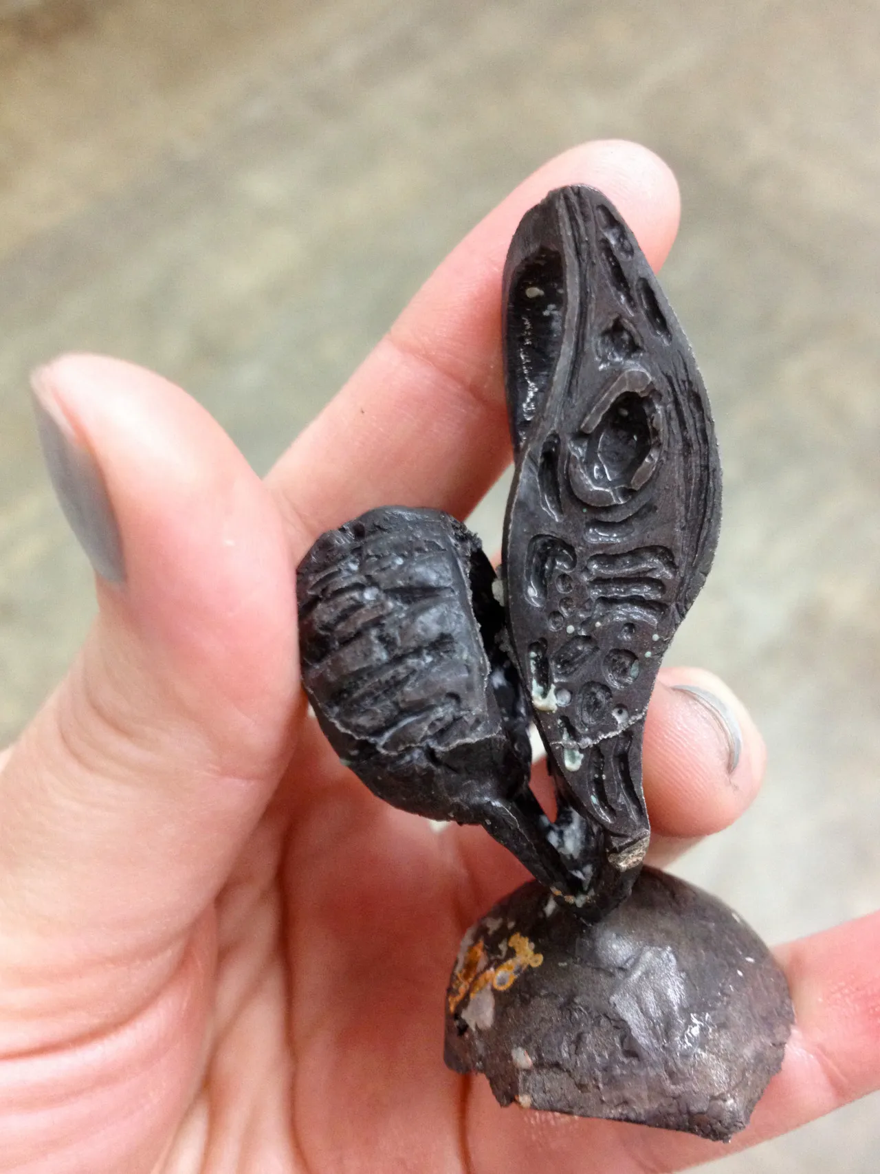 Hand holding the rough metal after casting